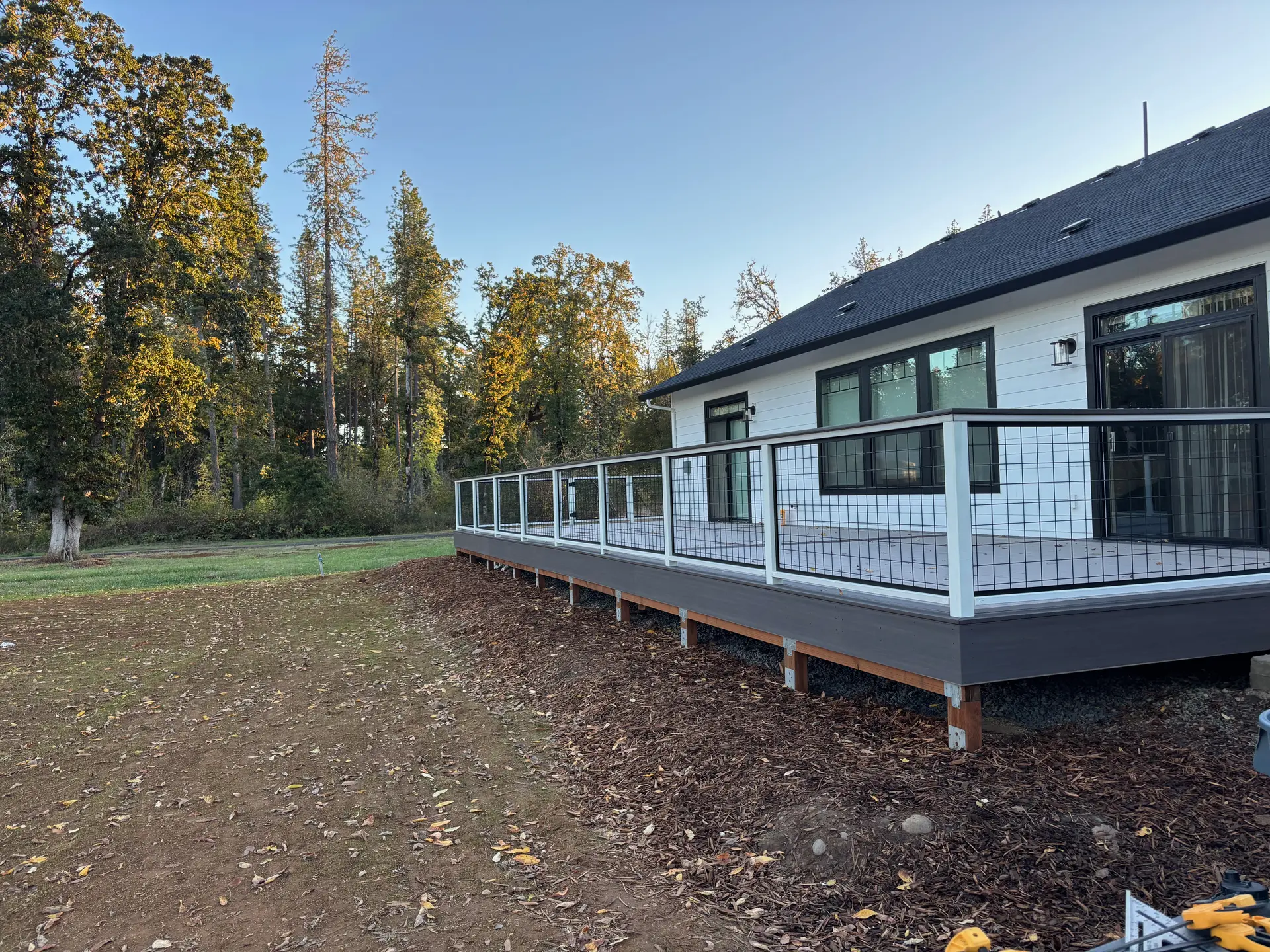 Finished TimberTech deck with black hog panel railing in Elmira, Oregon, by Tekton, a composite deck builder in Lane County