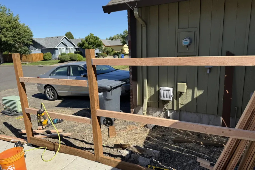Cedar fence rails framed between steel posts during construction by Tekton Construction