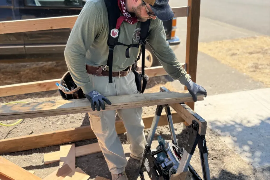 Tekton Construction crew member cutting cedar fence pickets on site