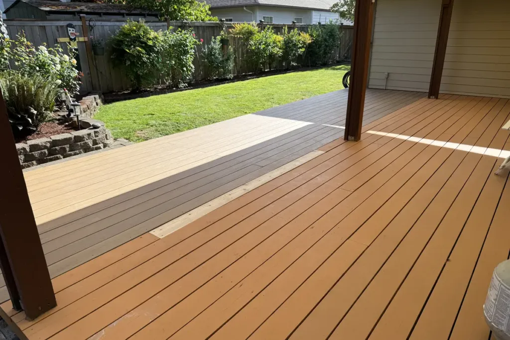 Two-tone composite decking with a darker border board cut around a patio cover post